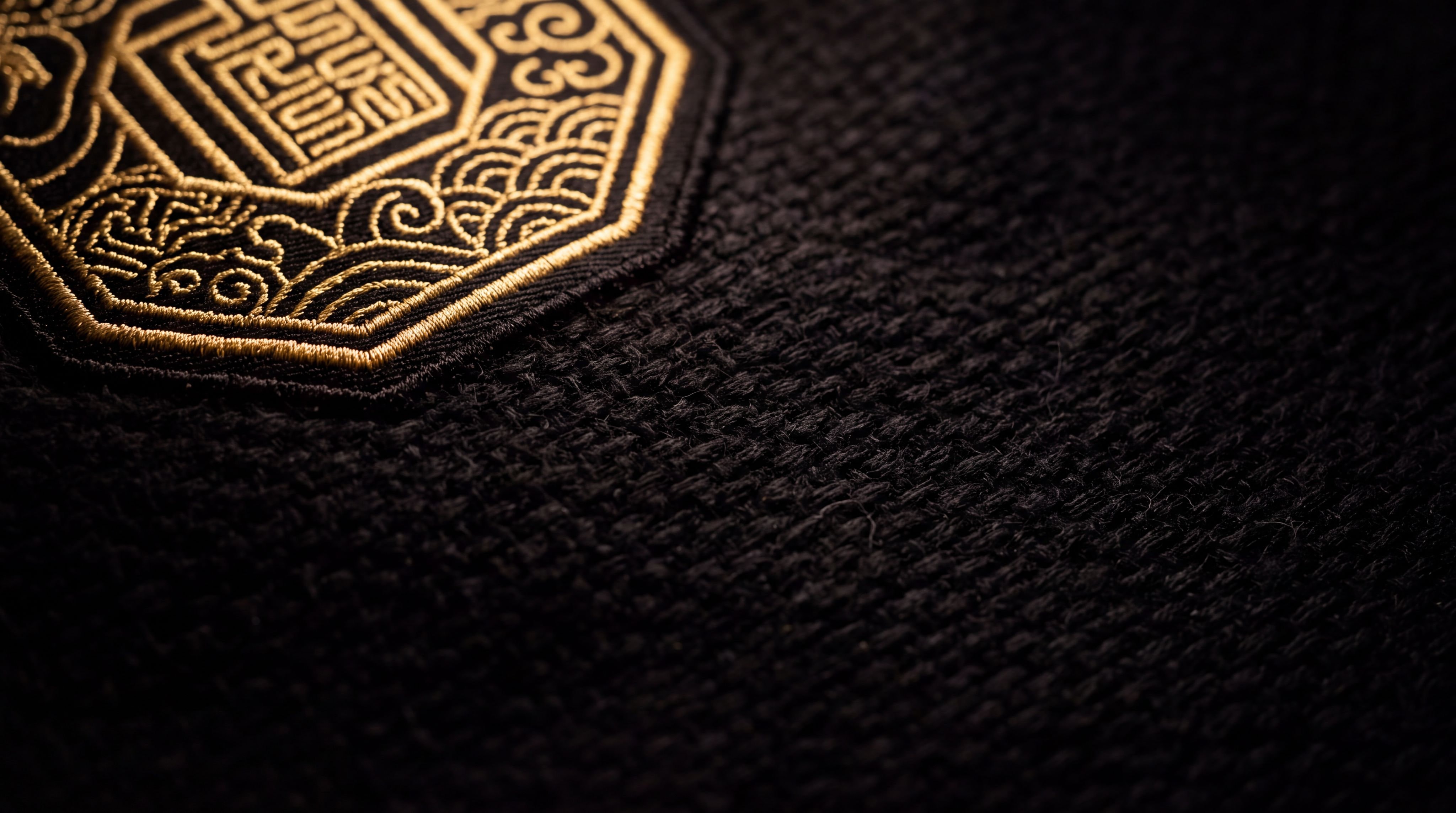 Black fabric with an emblem embroidered in gold thread